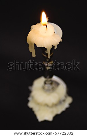 candle and candle holder against black background
