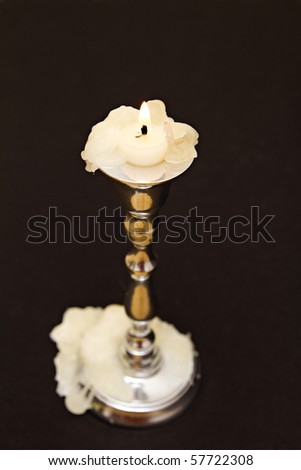 candle and candle holder against black background