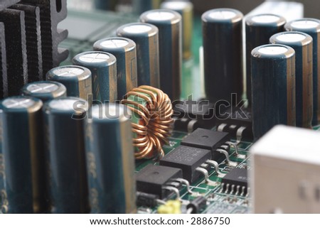 Close-up of computer mainboard with lots of capacitors in front. Selective focus.