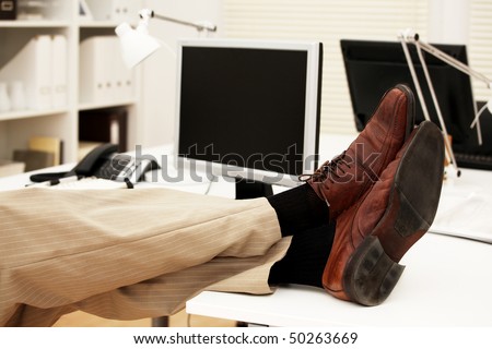 Feet of a businessman on the table in his office