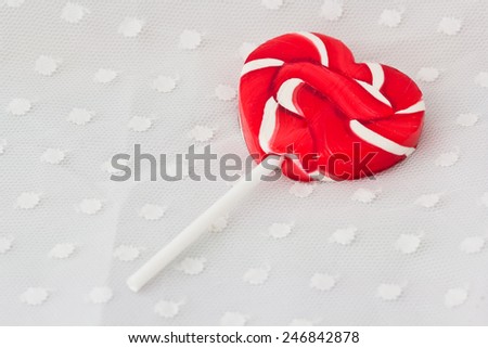 Lollipop in Heart Shape. Valentines Day Candy on white dot fabric background
