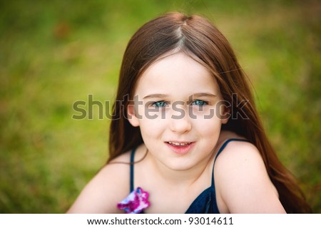 A beautiful portrait of a young brunette six year old in the outdoors