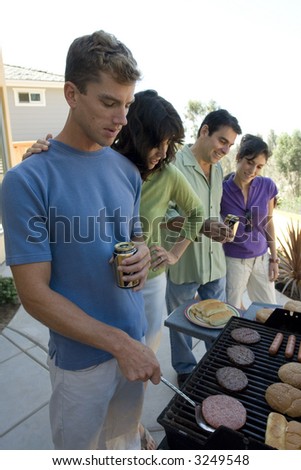 portrait of friends grilling hamburgers on the BBQ