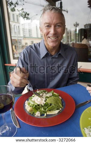 Portrait of an older man eating a salad
