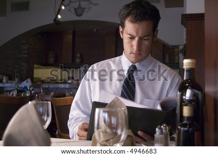Man looking at a menu in a fancy restaurant