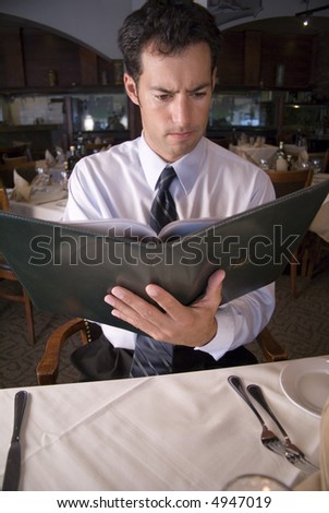 Man looking at a menu in a fancy restaurant
