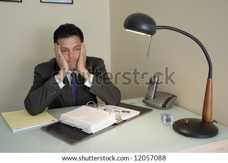 Portrait of a business man bored at his work desk
