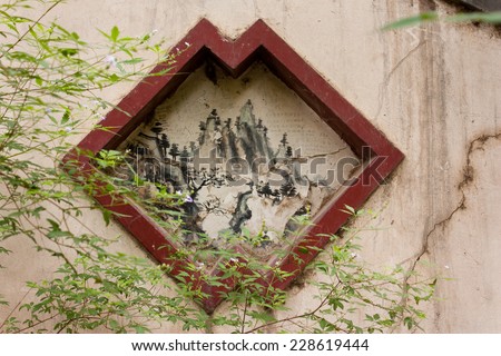 Ancient drawing with red frame inset into a cracked wall near Boya Pagoda at Peking University, Beijing