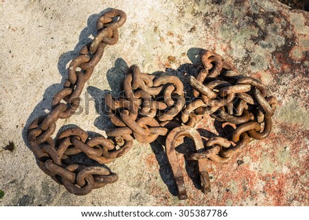 Old and rusty chain on stones
