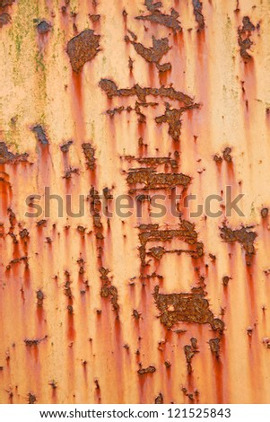 vertical part of old weathered metal with orange paint and stains