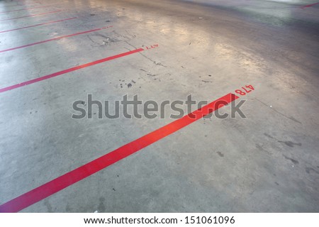 red lines and numbers on the floor of empty parking garage