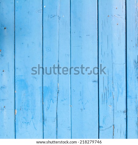 light blue painted planks of old shed with peeling paint