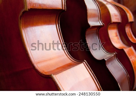 closeup of four double basses in a row