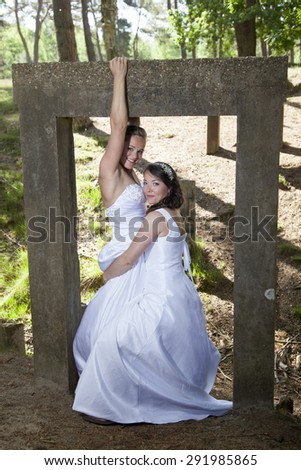 picture of two brides under old concrete object in nature surroundings