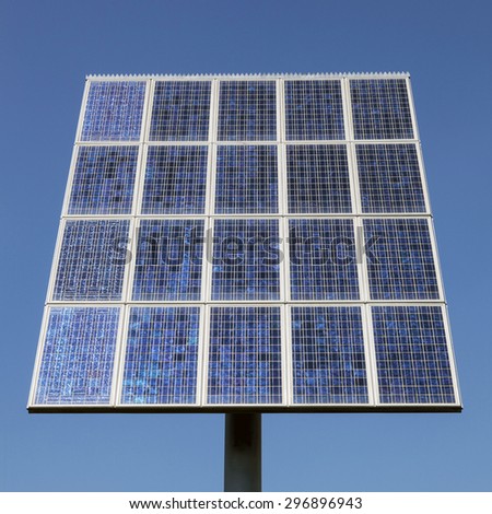 closeup of a chess board pattern of solar panels close together and blue sky