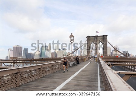 New York City, 13 september 2015: people engaged in bike run and others running on brooklyn bridge new york with manhattan in the background