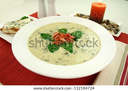 Creamy spinach soup with crispy bacon and spinach leaves.