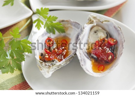 Delicious sweet chili oysters with parsley ready to serve.