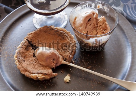 Beautiful fresh baked chocolate tart with melted caramel ice cream.