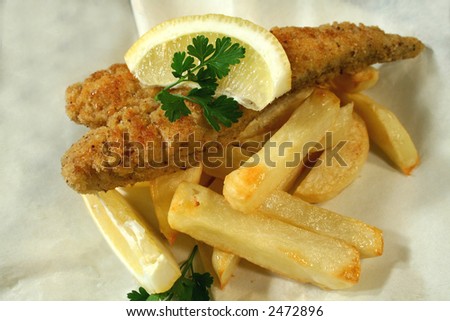 Classic fish and chips meal of crumbed whiting fillet with chips in paper.