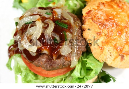 Delicious gourmet beef burger with steak sauce on a herb roll.
