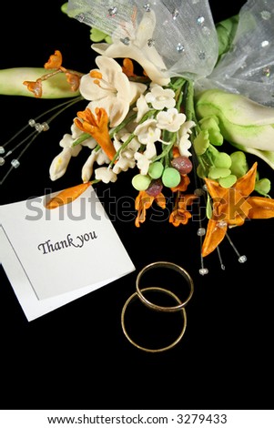 Wedding thank you with rings and bouquet.