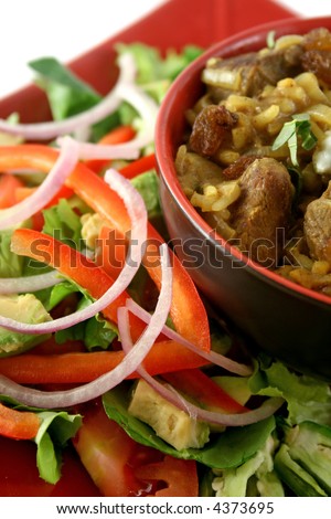 Indian lamb biryani with sultanas and yoghurt and a side salad.