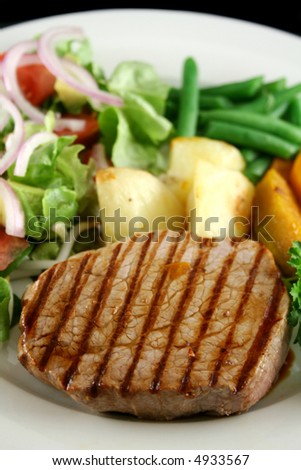 Hearty dinner of steak, vegetables and a side salad.