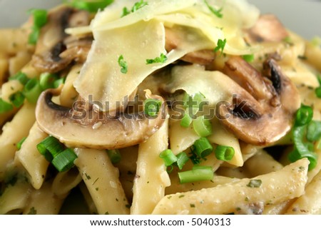Creamy mushroom penne pasta with shredded cheese.