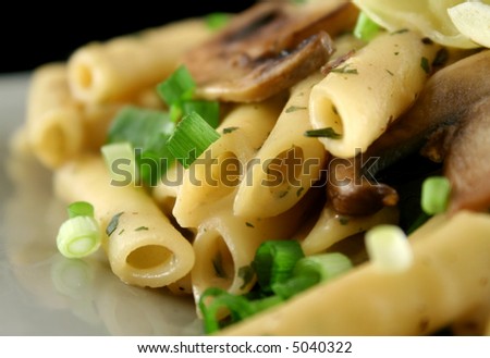 Creamy mushroom penne pasta with shredded cheese.