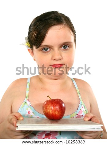Little girl with red apple on top of a book.