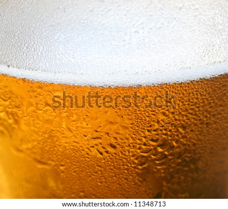 Close up background of a foaming glass of beer.