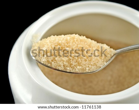 Spoonful of raw sugar on a spoon ready for coffee.