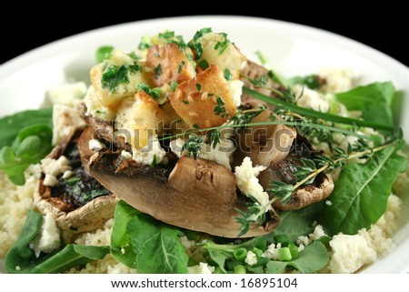 Mushrooms with ricotta cheese on couscous with herb croutons and rocket salad.