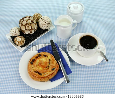 Delicious sultana danish pastry with a cup of black coffee and milk.