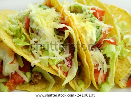 Delicious beef tacos with beef, lettuce, tomato salsa, avocado, grated cheese and sour cream.