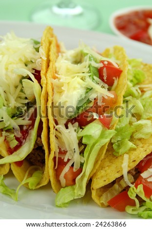 Delicious beef tacos with beef, lettuce, tomato salsa, avocado, grated cheese and sour cream.