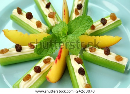 Healthy afternoon snack of celery sticks with cream cheese and sultanas.