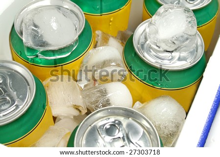 Icy cold cans of drinks in a plastic cooler.