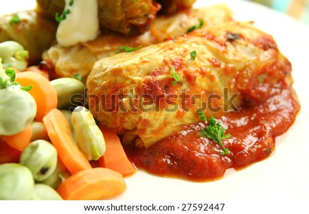 Baked cabbage rolls with carrots and broad beans with a tomato sauce.