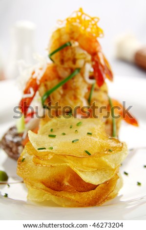 Stack of crisp potato chips with a shrimp stack in the background.