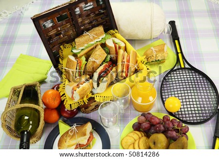 Selection of food for a picnic with a hamper, basket and fruit.
