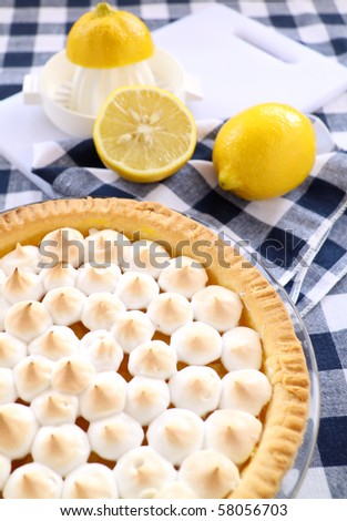 Delightful lemon meringue pie with fresh lemons ready to serve.
