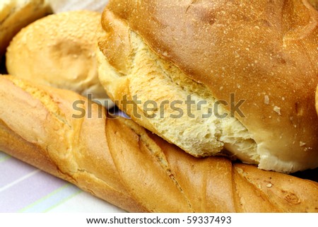 Background of different bread textures with loaves and bread rolls.