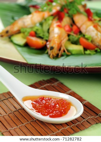 Delicious Asian chilli shrimp skewers with salad and sweet chili sauce.