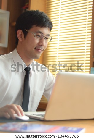 asian business man, happy working with laptop
