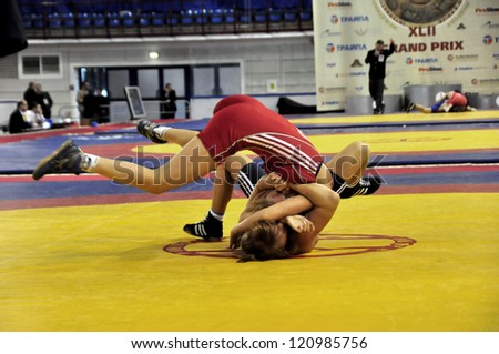 MINSK, BELARUS - SEPTEMBER 16: Unidentified female (red) scores a three point throw during Grand Prix for the prizes A.Medved in freestyle wrestling on September 16, 2012 in Minsk, Belarus.