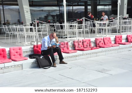 OSLO, NORWAY - AUGUST 16: Unidentified man reading near Opera House on 16 August 2012 in Oslo, Norway.