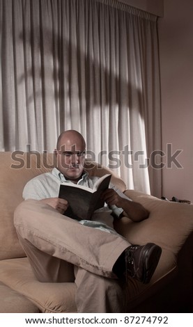 a man reading a book, in a dark night