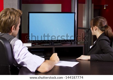 Business team watching a blank tv screen